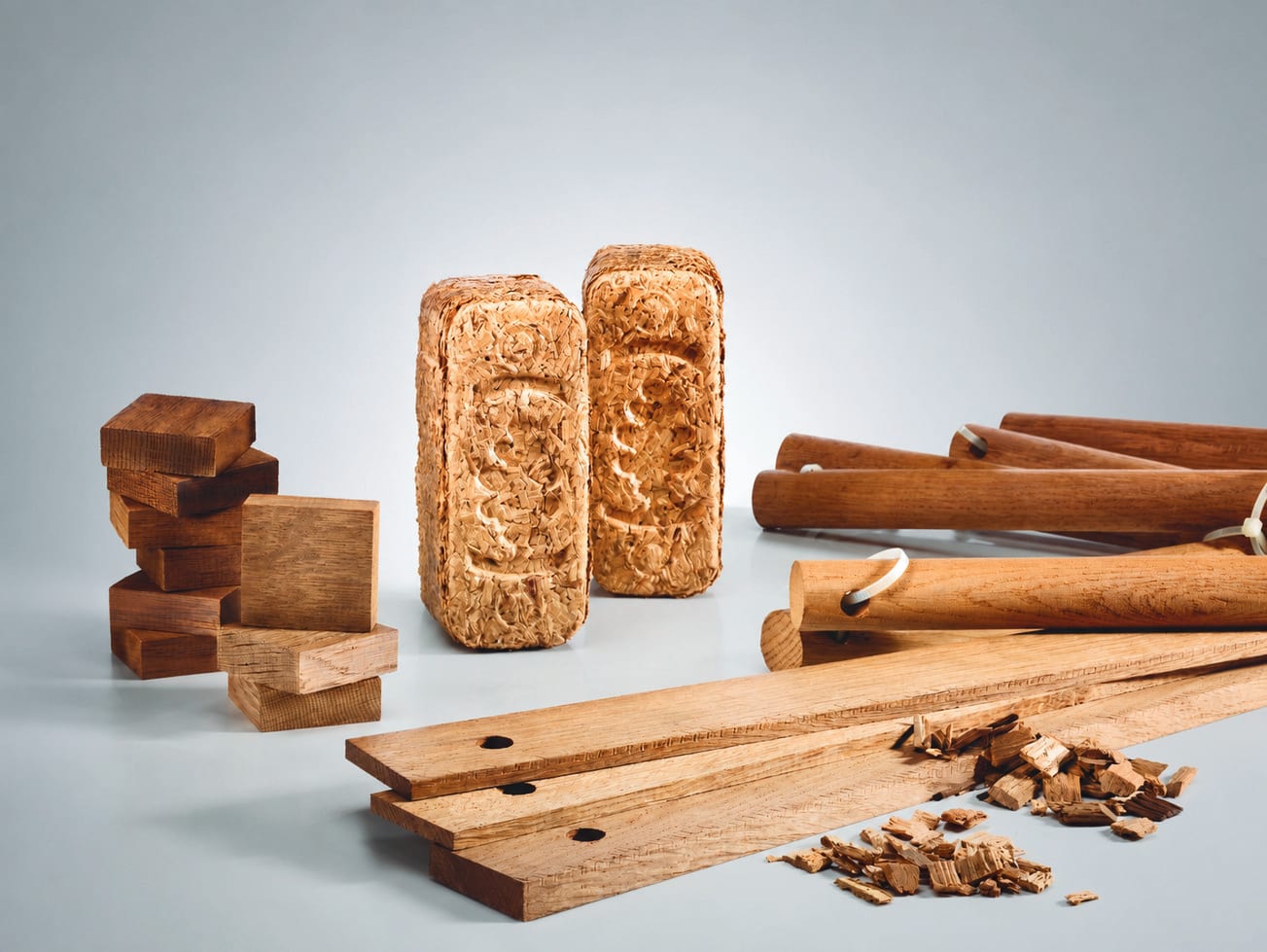 Oak chips, blocks, staves and sticks arranged on a pale surface
